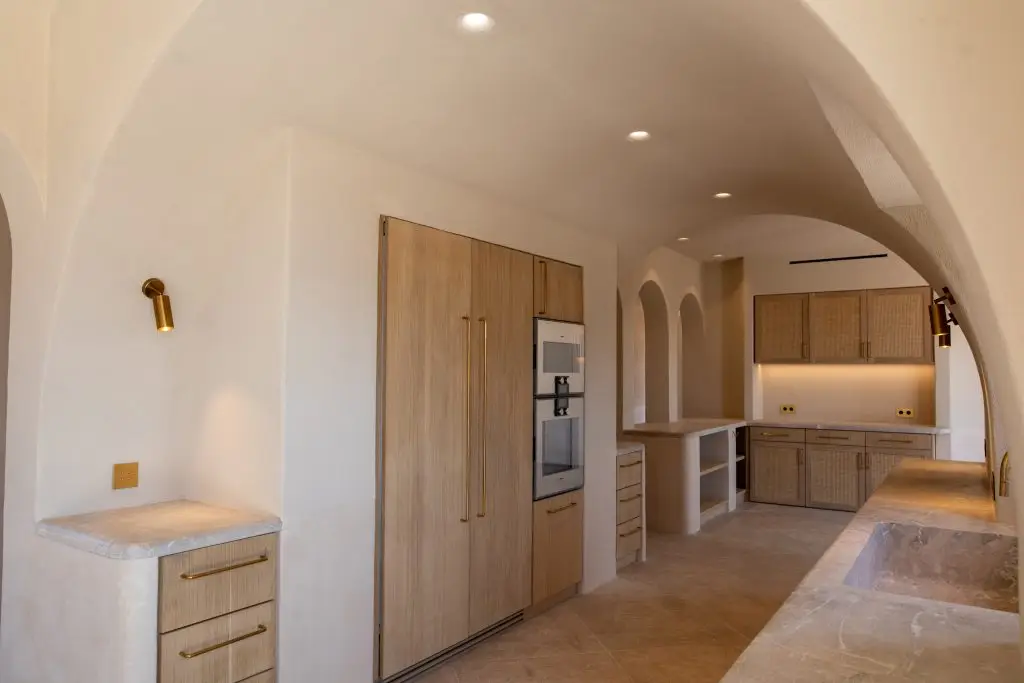 Cocina con superficies de piedra y armarios de madera en Santa María del Camino