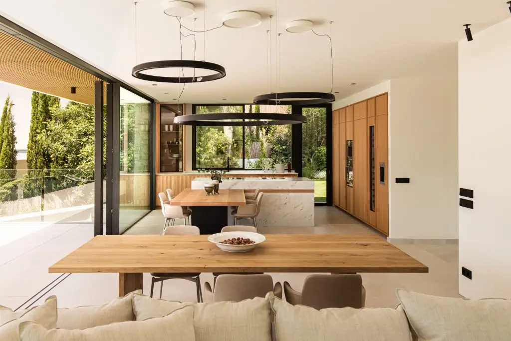 Dining area and kitchen with natural wood finishes at the Old Bendinat villa