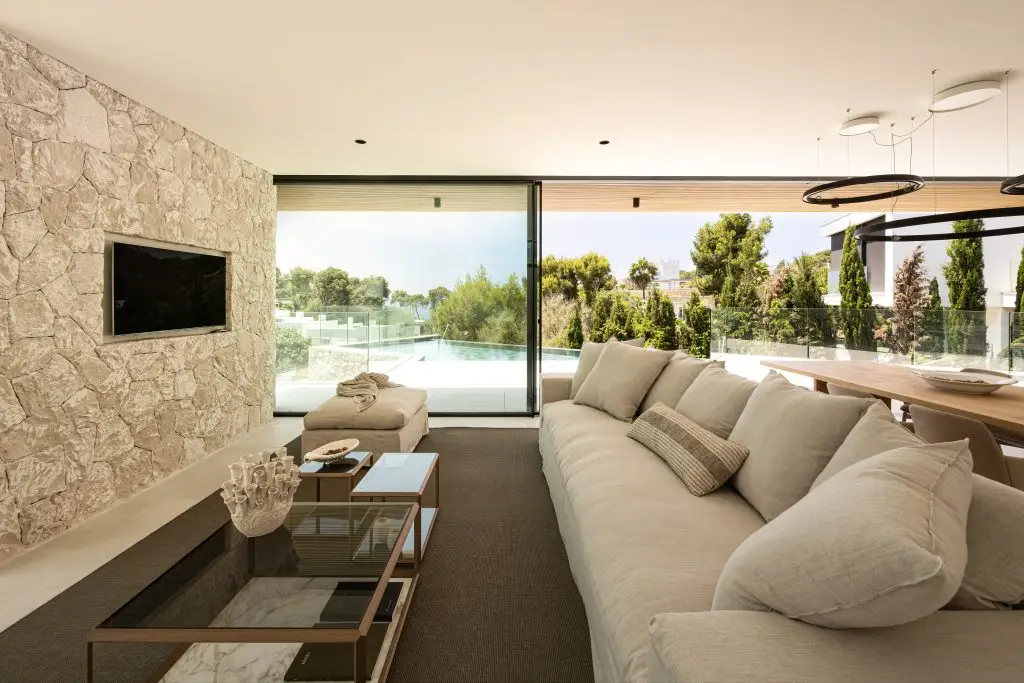 Living room with fireplace and pool views at the Old Bendinat villa