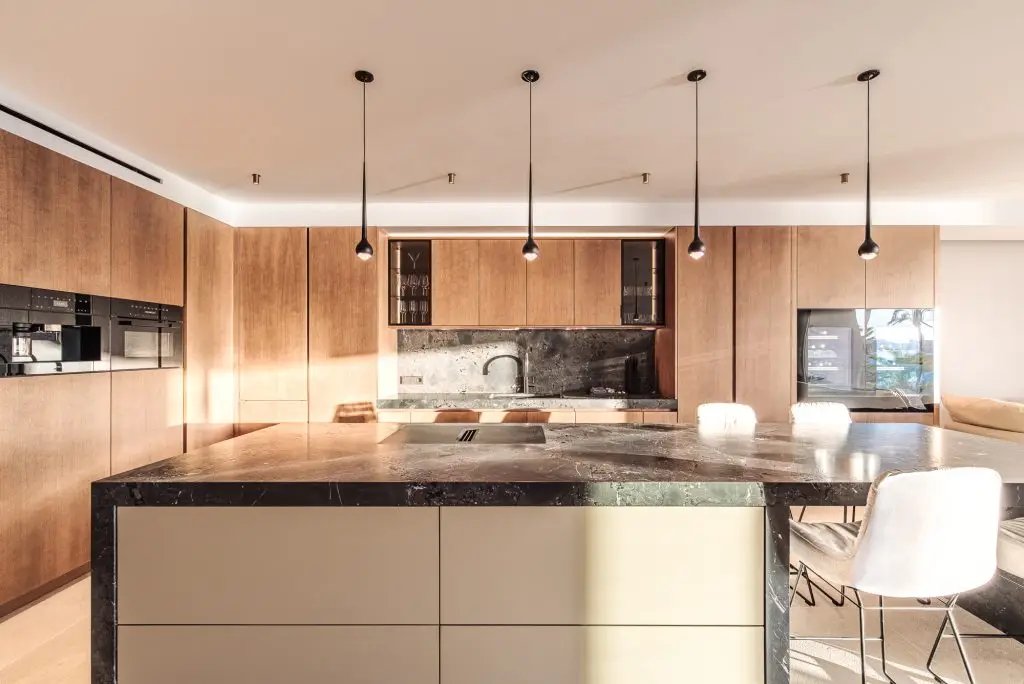 Kitchen with stone island and wood cabinetry at the Portixol duplex
