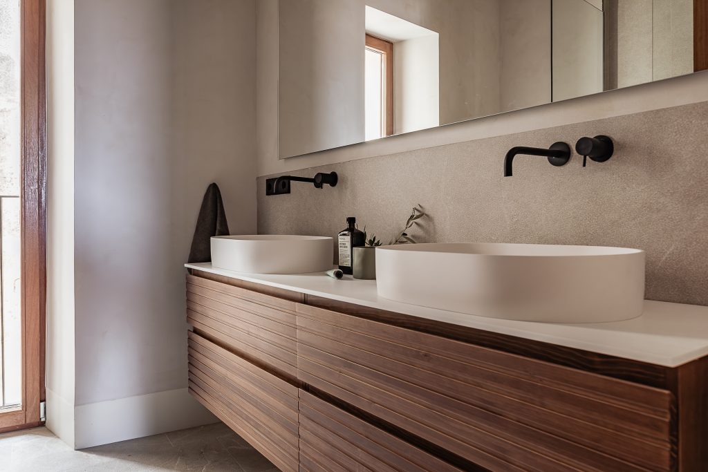 Double bathroom vanity with wood cabinetry at the Lloseta townhouse