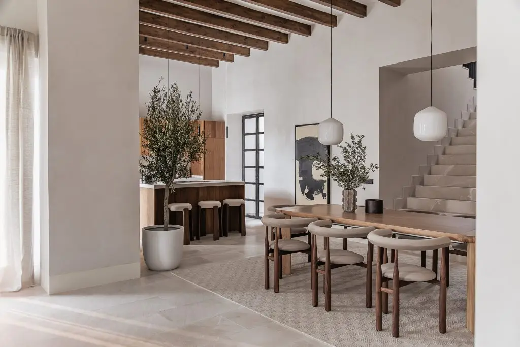 Dining room and kitchen with exposed timber beams at the Lloseta townhouse