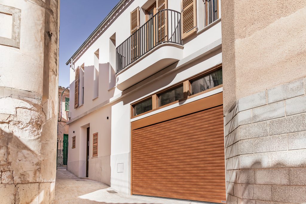 Restored townhouse facade beside the church at the Lloseta townhouse